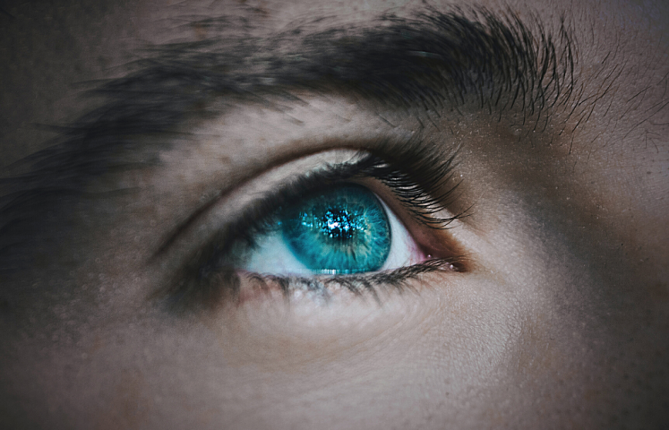 Osittainen kasvokuva, jossa sininen silmä.