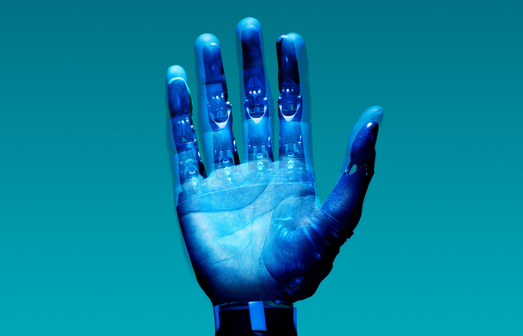 Ihmiskättä muistuttava robottikäsi sinistä taustaa vasten.