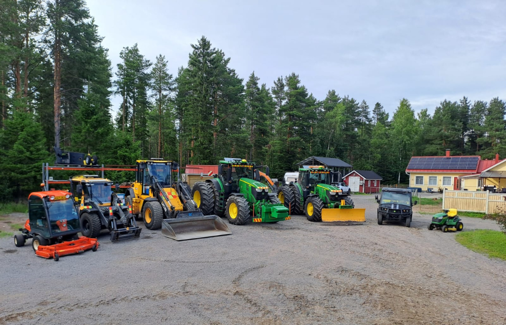 Yrityksen työkoneita rivissä pihamaalla.