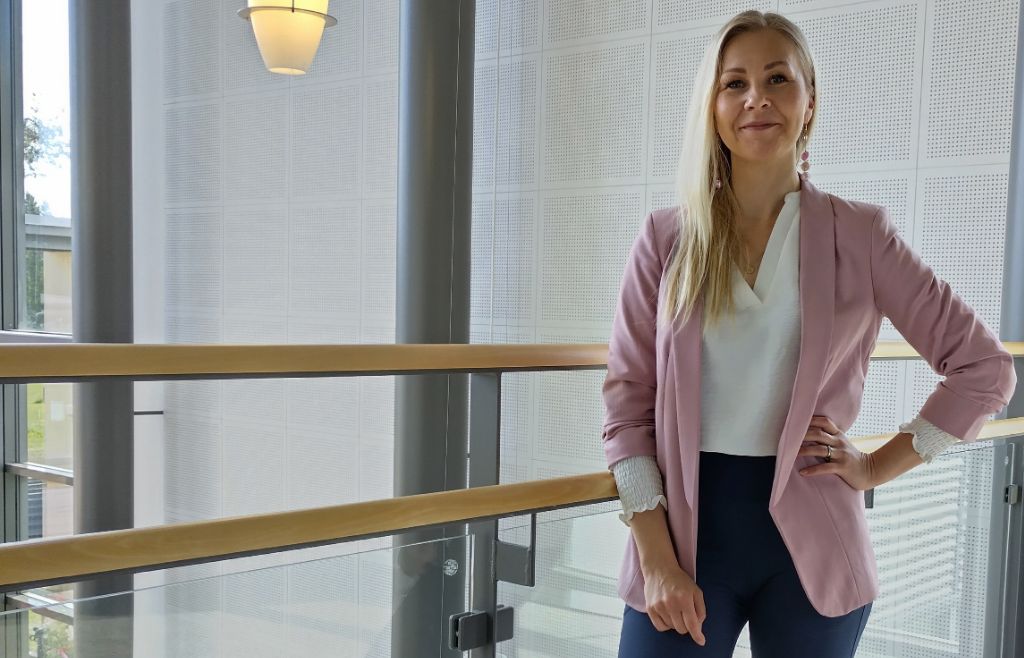Henkilökuva Katja Mattilasta seisomassa kaiteen vieressä.