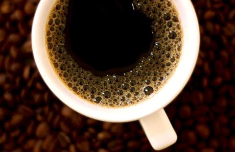 Mustaa kahvia sisältävä kahvikuppi ylhäältä päin kuvattuna.